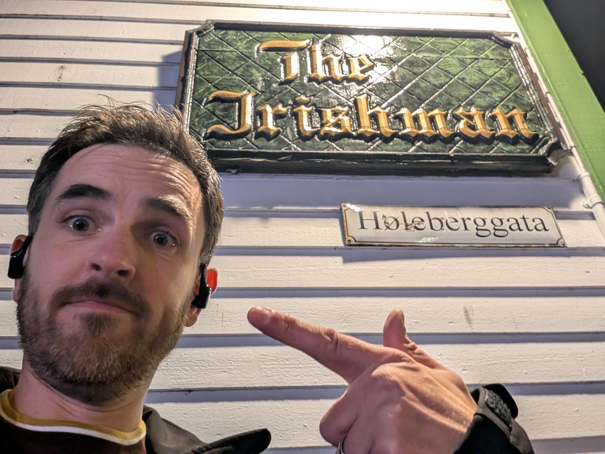 Pointing at the sign for The Irishman pub